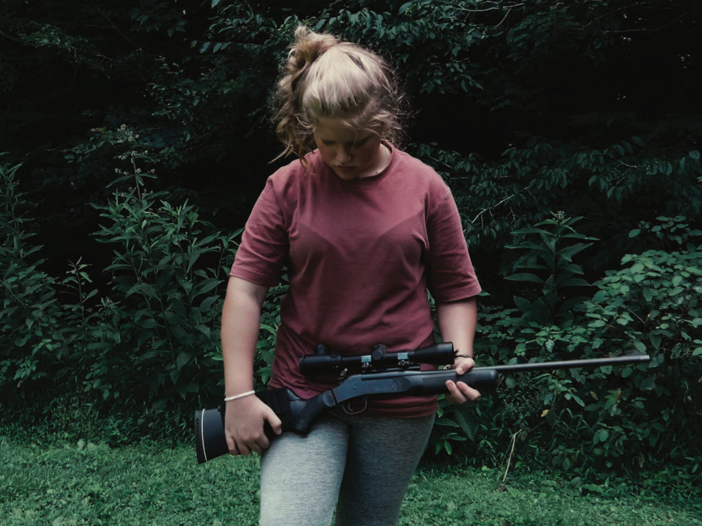 Une jeune fille tient une arme à feu dans The Last Hillbilly