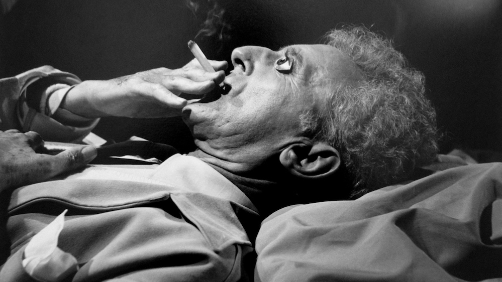 Le poète, sur son lit de mort, grille une dernière cigarette, dont la fumée mime l'âme s'échappant du corps.